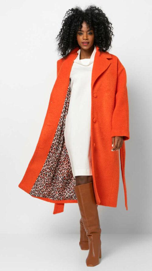 Oversized πορτοκαλί παλτό με τσέπες και εμπριμέ φόδρα. Διαθέτει ασορτί αποσπώμενη ζώνη.