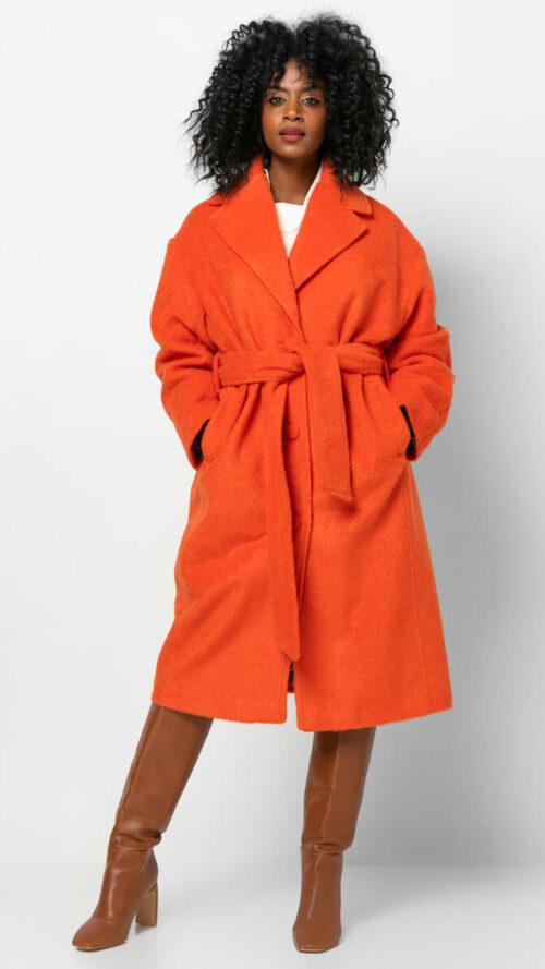 Oversized πορτοκαλί παλτό με τσέπες και εμπριμέ φόδρα. Διαθέτει δεμένη ασορτί αποσπώμενη ζώνη.